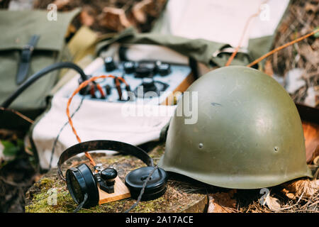 Russian Soviet Portable Radio Transceiver Used By USSR Red Army Signal Corps In World War Ii. Headphones, Telegraph Key And Helmet Are On A Forest Stu Stock Photo