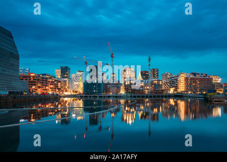 Oslo, Norway. Night View Embankment And Residential Multi-storey House In Gamle Oslo District. Summer Evening. Residential Area Reflected In Sea Water Stock Photo