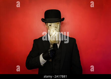Man in Dark Suit with Rusty Meat Cleaver Hiding His Face. Concept of Horror Movie Murderer. Scary and Creepy. Dark Stock Photo. Stock Photo