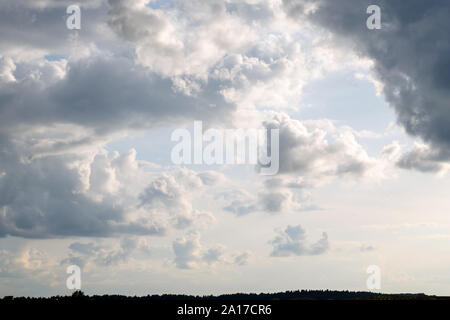 Gray and white clouds in the blue sky above the ground closeup Stock Photo