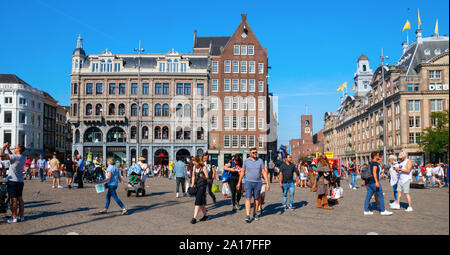 Dam Square and Damrak, crowded with sightseeing tourists in summer,  The Netherlands. Dam Square is a major tourist attraction of Amsterdam. Stock Photo