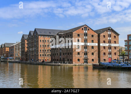 GLOUCESTER QUAYS, ENGLAND - SEPTEMBER 2019: Boat moored alongside new apartments in the regenerated former docks in the Gloucester Quays. Stock Photo