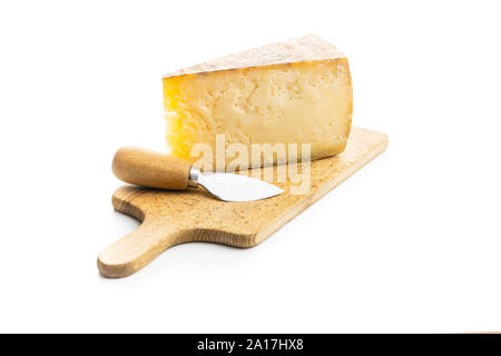 Block of tasty cheese on cutting boars and cheese knife isolated on white background. Stock Photo
