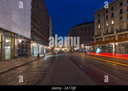 Milan, Italy - March 18, 2017: Piazza Cordusio at dusk, the Sforza Castle in the background, in the foreground light trail left by the passing tram