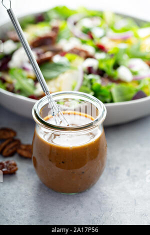 Balsamic vinaigrette dressing for a salad, small glass jar with a whisk Stock Photo