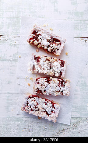 Shortcrust plum cake with coconut crumble, freshly baked. Concept for a tasty sweet dessert. Bright wood background. Top view. Close up. Stock Photo