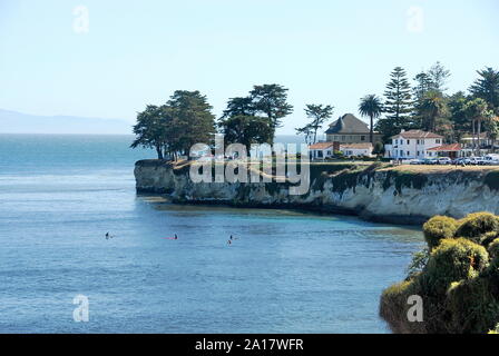 Surfers below West Cliff Drive with its houses and cliff above Cowell