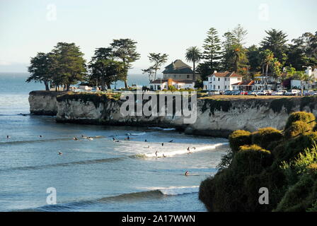 Surfers below West Cliff Drive with its houses and cliff above Cowell