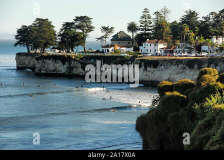 Surfers below West Cliff Drive with its houses and cliff above