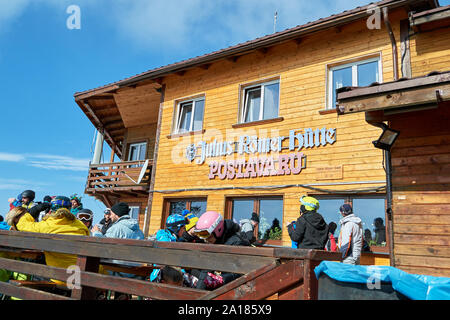 Poiana Brasov, Romania - February 20, 2019: Skiers and tourists having a break at Julius Romer Hutte / Postavaru hut on a sunny Winter day. Stock Photo