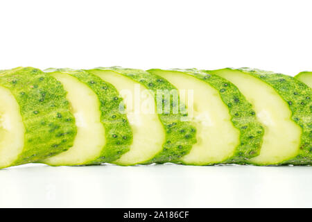 Lot of slices of fresh green pickling cucumber in line isolated on white background Stock Photo