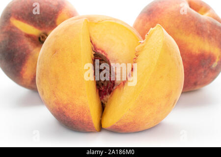 Group of three whole fresh fuzzy peaches one sliced isolated on white background Stock Photo