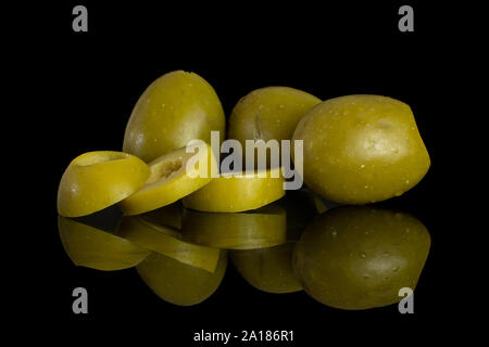 Group of three whole three slices of pitted green olive isolated on black glass Stock Photo