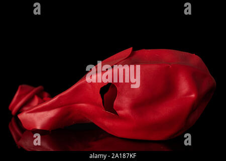 One whole red latex pastel ballon isolated on black glass Stock Photo