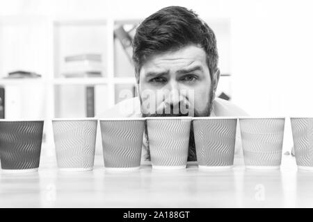 Choose from alternatives. Man bearded choosing one of lot colorful paper cups. Alternative concept. Pick one. Diversity and recycling. Eco paper cup. Coffee to go paper cup. How many cups per day. Stock Photo