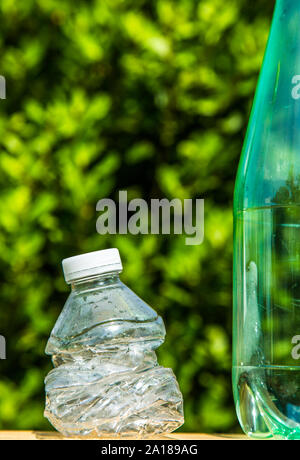 Two plastic bottles with one bottle crushed to illustrate recycling Stock Photo