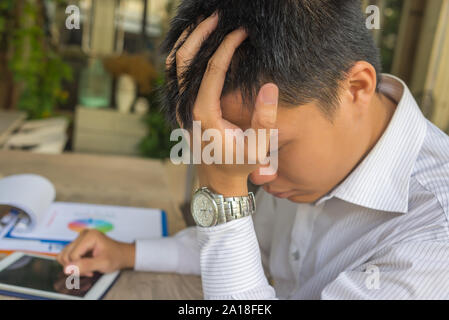 Frustrated young businessman having headache at business office Stock Photo