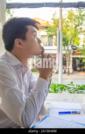 Young businessman thinking about business solution at outdoors background Stock Photo