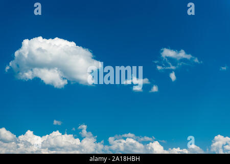View of the sky with a single loose cumulus cloud pile and a continuous cloud band at the bottom of the picture. Stock Photo