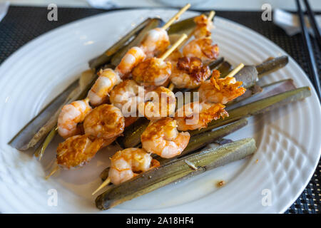Plate of delicious grilled shrimp and seafood skewers in restaurant Stock Photo