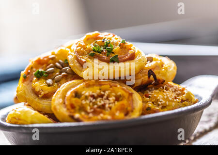 Rolls of puff pastry with ham bacon cheese sesame in dish Stock Photo