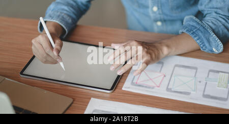 Cropped view of professional male UX web designer working on his new smartphone templates project while using blank screen tablet Stock Photo