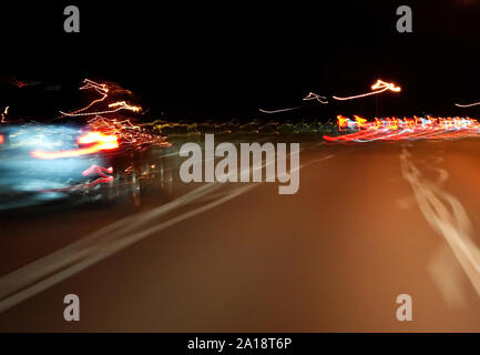 Distorted night view of cars, lights, and street lines from drunk, drugged, sleepy, or medicated drivers. Stock Photo