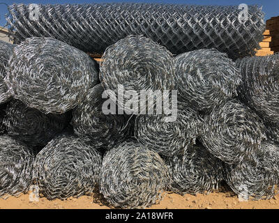 Rolled chain-link fence. Metal mesh netting rolled into rolls. Stock Photo