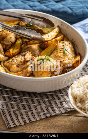 Chicken legs roasted with american potatoes in baking dish Stock Photo