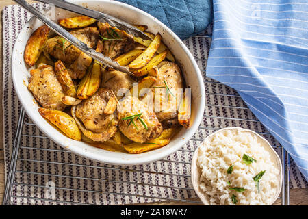 Chicken legs roasted with american potatoes in baking dish Stock Photo