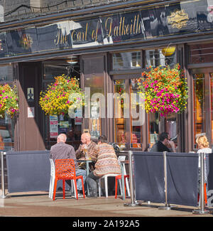 Customers sit outside the Earl of Dalkeith pub in the shopping centre at Kettering, Northamptonshire, England, on a sunny day. Stock Photo