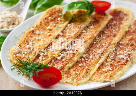 Vegan breadsticks with garlic and cashew cheese served with tomatoes and basil on wooden cutting board Stock Photo