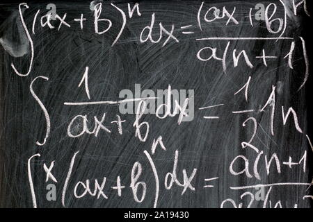 Math formulas written in chalk on school background, close up Stock Photo