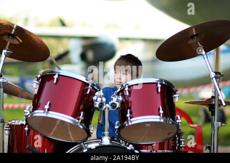 Boy learning to drum at the open air festival Stock Photo
