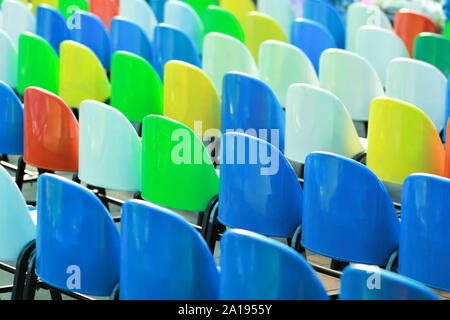 Rows of colorful plastic chairs, back view Stock Photo