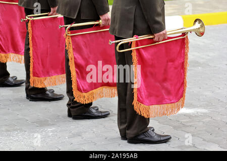 Parade of military orchestra holding musical instrument trumpet with red flag Stock Photo