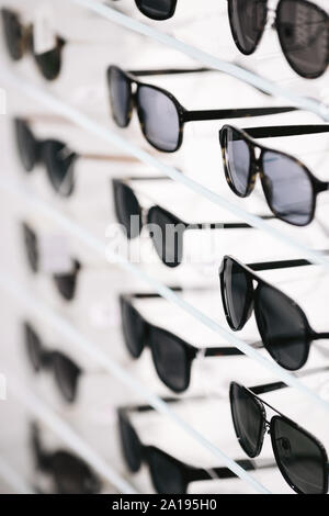 Fashionable sunglasses on a shelf in optical store