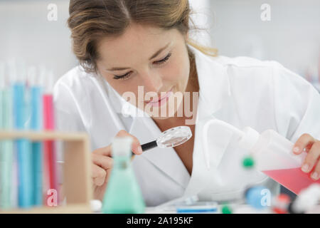 female scientist using magnifying glass Stock Photo