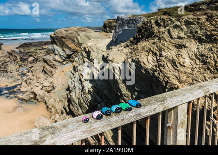A set of hand painted pebbles arranged on the footbridge connecting the mainland and Porth Island at Porth Beach in Newquay in Cornwall. Stock Photo