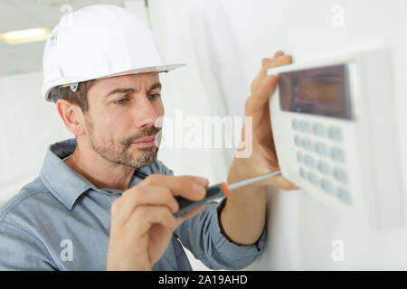 close-up of male plumber fixing thermostat Stock Photo