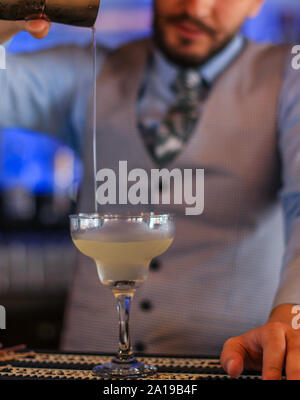 Bartender preparing an alcoholic cocktail behind a bar. Barman. Stock Photo