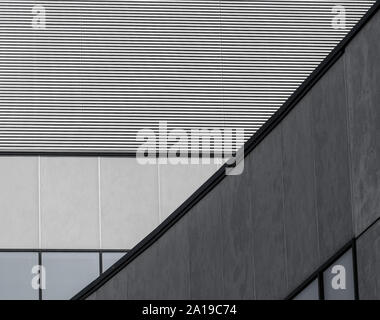 fragment of gray concrete building with a striped wall and empty windows closeup Stock Photo