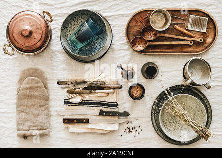 Various kitchen utensils and tablewear over rustic linen tablecloth Stock Photo