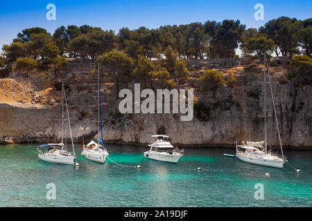 Sailboats moored in a bay of the rocky coast, Calanque de Port Pin, Provence, France, Europe