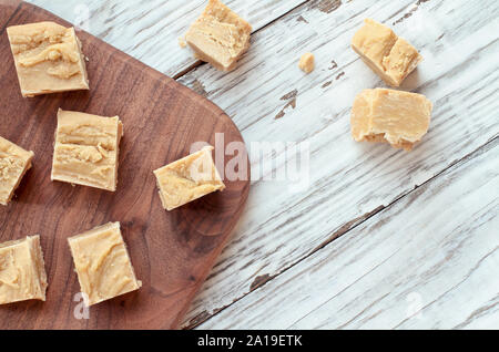 Squares of delicious, homemade peanut butter fudge over a rustic wood table background. Image shot from top view. Stock Photo