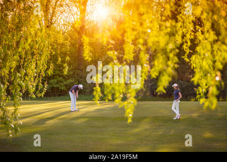 Golf player couple on green. Stock Photo