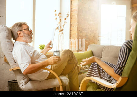 Senior man working with tablet at home - concept of home studying. Caucasian male model doing his homework with teacher while serfing in internet, watching cinema or webinar, online lessons. Stock Photo