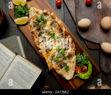 Turkish pide with meat chees herbs and lemon slices Stock Photo