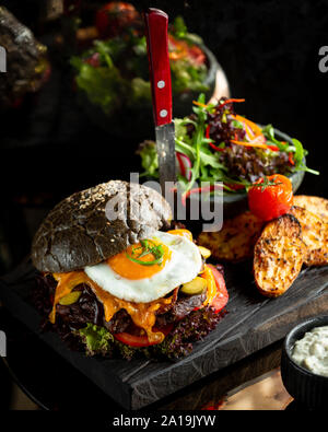 Cheeseburger with bacon and egg in brown bread Stock Photo