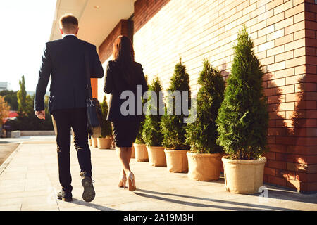Back view. Business People walk along the city street. Stock Photo